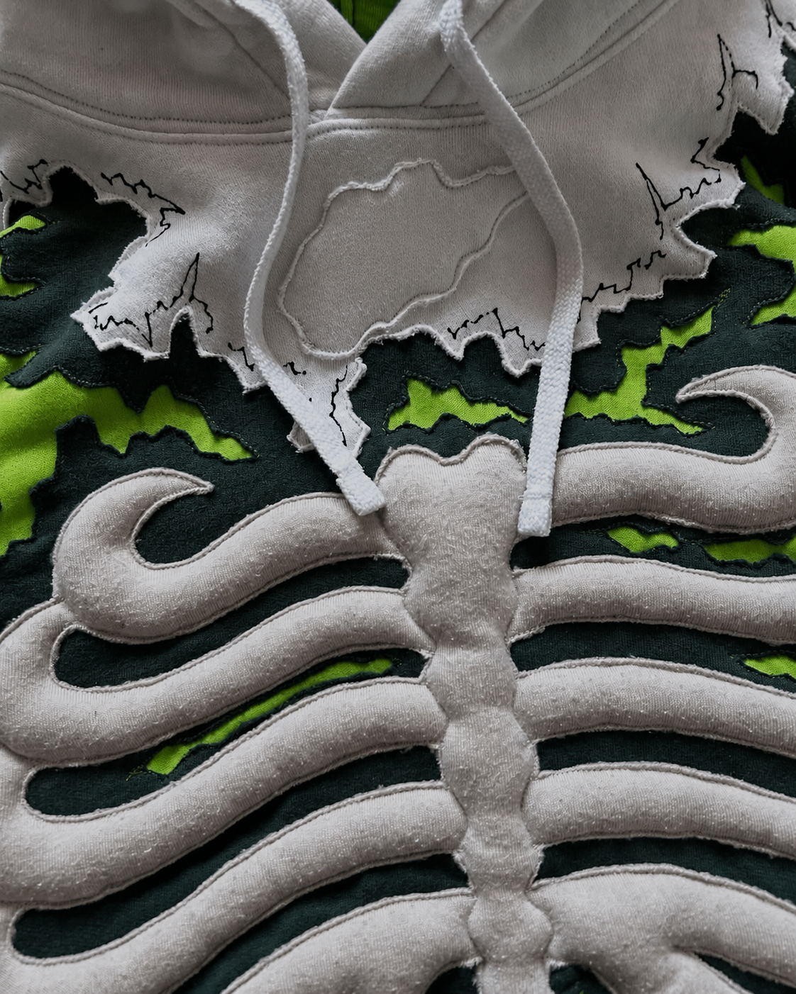 Close-up of Noctra Venom Core hoodie 3D skeletal appliqué detailing